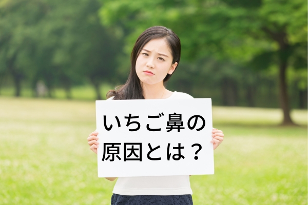 いちご鼻の原因とは？というプレートを持って困った顔をしている女性