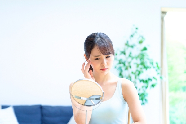 鏡の前で悩む女性