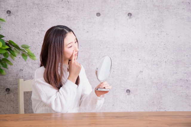 鏡を見る悩む女性