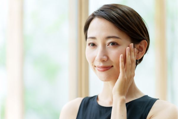 片手を頬に当てる女性