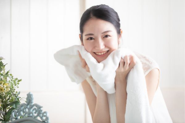 タオルで顔をふく女性