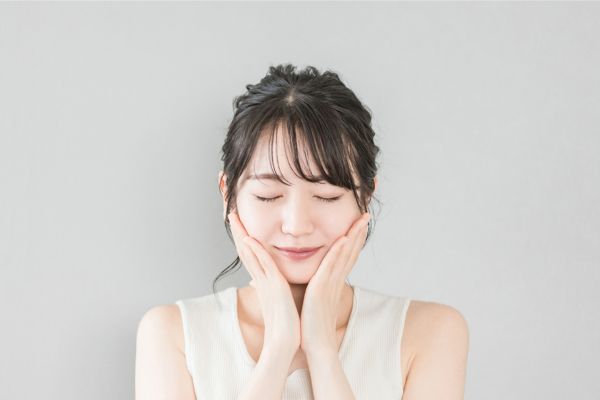 頬を触る女性