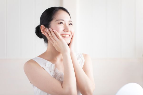 両頬を触る女性